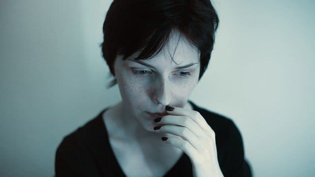 Feeling stuck A thoughtful woman looking down with her hand to her mouth