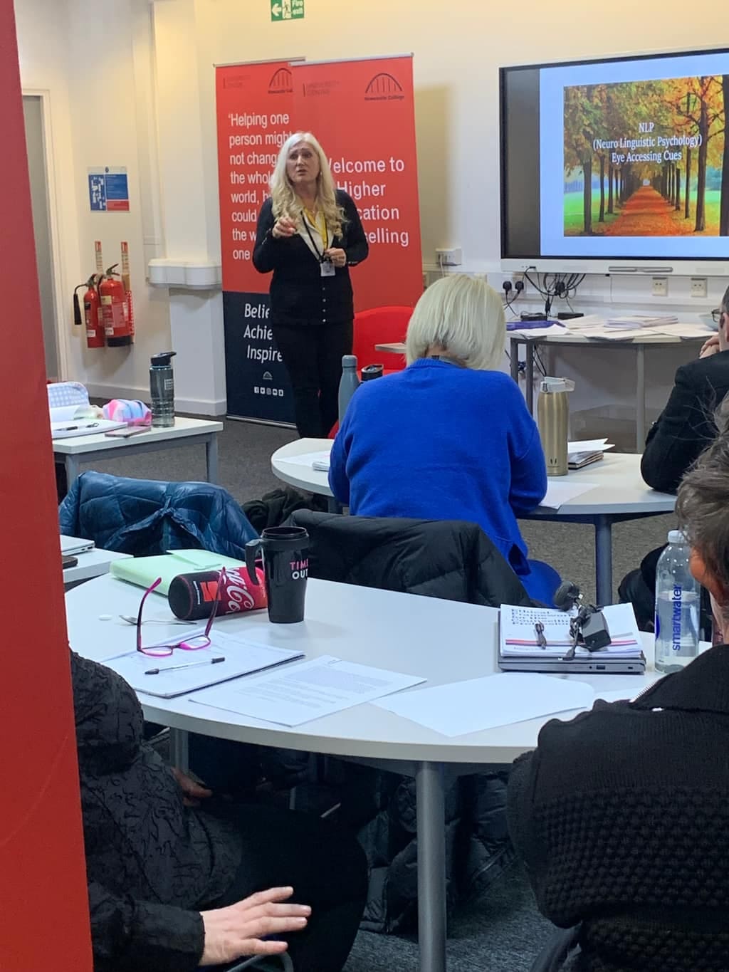 Sonya Hudson presenting to a training group seated at tables